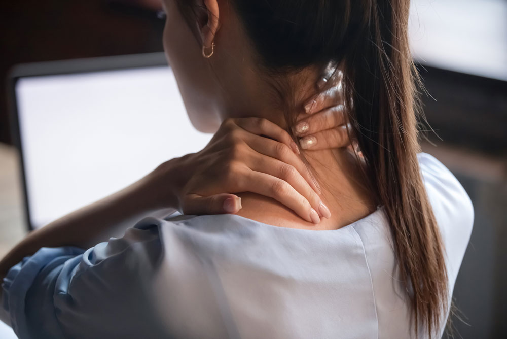 A lady holding her painful neck